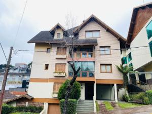 a house with a tree in front of it at MRG - Faça tudo a pé - 1D no Centro de Gramado in Gramado