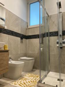 a bathroom with a toilet and a glass shower at Neptune in Francavilla al Mare