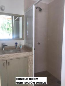 une salle de bain avec une douche, un lavabo et un miroir dans l'établissement Sea by C Apartments, à Cancún