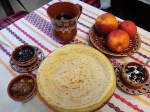 una mesa cubierta con un plato y tazones de fruta en Topalovi Guest House, en Zlatograd