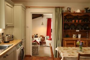 eine Küche mit Tisch und ein Esszimmer in der Unterkunft Drumena Cottage in Kilcoo