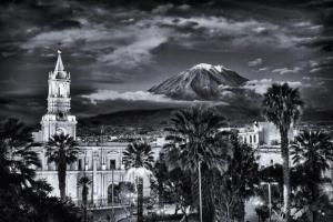 a tall tower with a clock on top of it at Katari Hotel at Plaza de Armas in Arequipa
