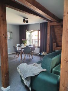 ein Wohnzimmer mit einem grünen Sofa und einem Tisch in der Unterkunft Apartamenty K17 in Malbork