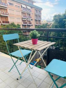 una mesa con 2 sillas y una maceta en el balcón en Modern City Apartment en Modena