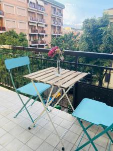 una mesa con 2 sillas y un jarrón de flores en el balcón en Modern City Apartment, en Módena