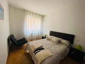Un dormitorio con una cama grande y una silla. en VUT LOURDES, en Arenas de San Pedro