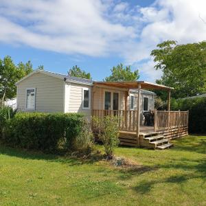 een tiny house met een veranda en een terras bij Mobil home 2020 3ch + clim , équipé 4* , vendée in Talmont