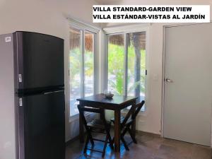 a kitchen with a small table and a refrigerator at Sea by C Apartments in Cancún