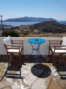 een blauwe tafel en stoelen op een balkon met uitzicht bij Anatoli in Kimolos