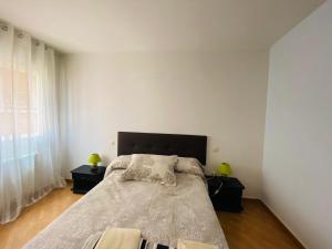Un dormitorio con una cama grande con dos mesitas de noche. en VUT LOURDES, en Arenas de San Pedro