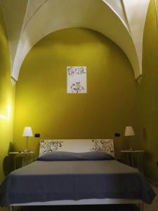 レッチェにあるLa Sciuscettaの黄色い壁のベッドルーム1室