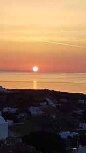 een zonsondergang boven de oceaan met de zon in de lucht bij Anatoli in Kimolos