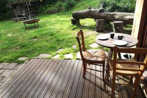 un patio con mesa y sillas en una terraza en Le chalet des carrières, en Chastre-Villeroux-Blanmont