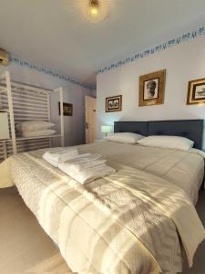 a large bed in a bedroom with blue walls at Flisvos sea view rooms in Parga