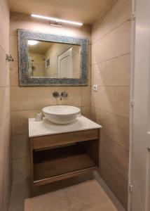 a bathroom with a sink and a mirror at Flisvos sea view rooms in Parga