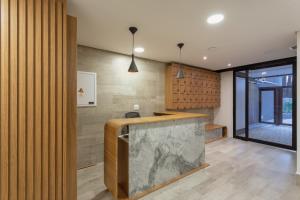 a lobby with a marble counter and wooden walls at Charlie Itaim Bueno Brandão in Sao Paulo