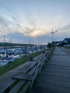 eine hölzerne Promenade neben einem Yachthafen mit Booten in der Unterkunft Gîte la bassurelle Classé trois étoiles in Étaples