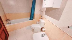 łazienka z toaletą, wanną i umywalką w obiekcie Amazing ocean view apartment w Corralejo +8 zdjęć