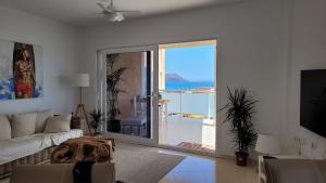 salon z kanapą i dużymi przesuwnymi szklanymi drzwiami w obiekcie Amazing ocean view apartment w Corralejo