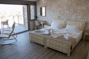 a bedroom with a large bed with towels on it at Panorama Studios in Kefalos