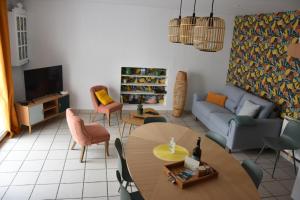 a living room with a table and a couch at Gîte la bassurelle Classé trois étoiles in Étaples