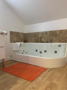 Gonneville-sur-Mer的住宿－Gite du golfe，铺有木地板的客房内设有白色浴缸。