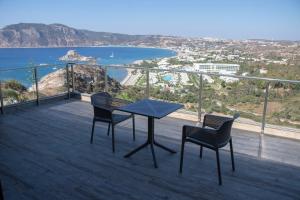 a table and chairs on a balcony with a view of the ocean at Panorama Studios in Kefalos