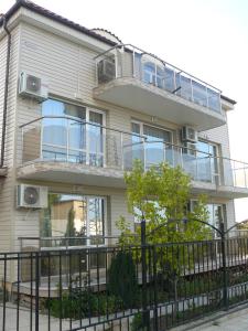 an apartment building with balconies and a fence at Morska Zvezda Guest House in Chernomorets