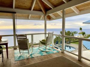 two chairs on a porch with a view of the ocean at Affordable Luxury, Fantastic Unobstructed Ocean View with Pool apts in Papa Bay Estates
