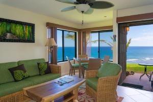 a living room with a green couch and a table at Sealodge G4 in Princeville