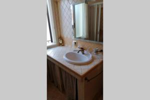 a bathroom with a sink and a mirror at Appartamento U scrusciu ro mari in Marzamemi