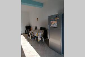 a kitchen with a table and a refrigerator at Appartamento U scrusciu ro mari in Marzamemi
