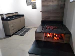 a kitchen with a stove with a fire in it at Hospedagem Alternativa - Ana Paula in São Joaquim