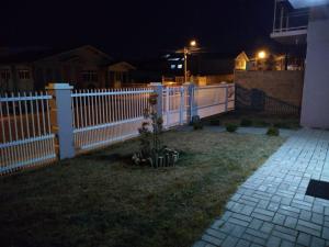 a white picket fence in a yard at night at Hospedagem Alternativa - Ana Paula in São Joaquim