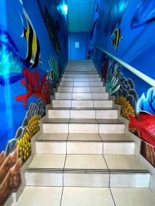 a row of stairs leading up to a room with blue walls at Mahana Lodge Hostel & Backpacker in Papeete