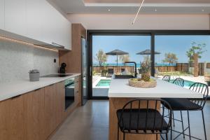 uma cozinha com uma ilha e vista para uma piscina em Alas Suites em Alykes