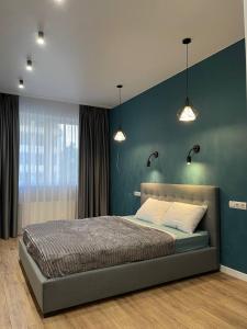 een slaapkamer met een bed met blauwe muren en verlichting bij Сдам квартиру в 51 жемчужине in Odessa