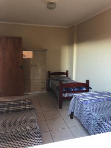 a bedroom with two beds and a cabinet in it at Aconchego - lar doce lar in Poços de Caldas