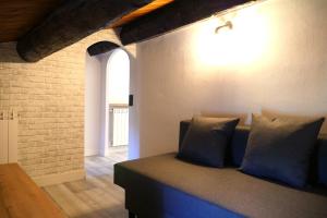 un sofá en una habitación con una pared de ladrillo en Rita, apartament ideal per a dos, en Tremp