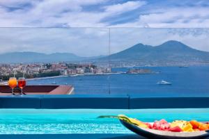 a bowl of fruit on a table with a view of the water at BW Signature Collection Hotel Paradiso in Naples