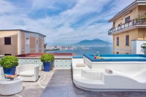 um pátio com mobiliário branco e uma piscina em BW Signature Collection Hotel Paradiso em Nápoles