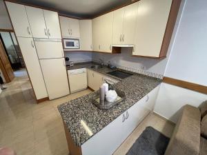 ログローニョにあるLaurel centroのキッチン(白いキャビネット、花崗岩のカウンタートップ付)