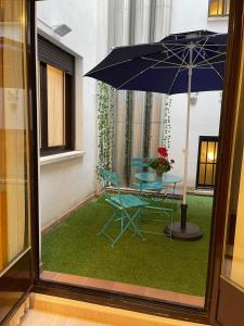 einen Tisch und einen blauen Stuhl mit einem Regenschirm in der Unterkunft Laurel centro in Logroño