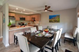 a kitchen and dining room with a wooden table and chairs at Puamana 25B in Princeville