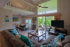 a living room with a couch and a tv at Puamana 25B in Princeville