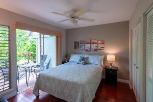a bedroom with a bed with a ceiling fan at Puamana 25B in Princeville