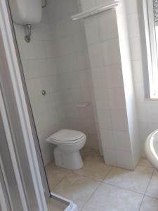 a white bathroom with a toilet and a sink at Emilù a mare in Schiavonea