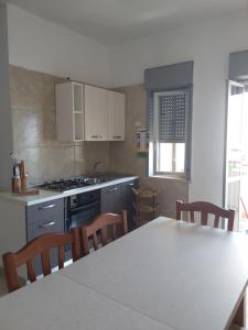 a kitchen with a table and chairs and a stove at Emilù a mare in Schiavonea