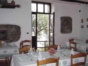 un comedor con mesas y sillas blancas y una ventana en Agriturismo La Casa Vecchia, en Ascea