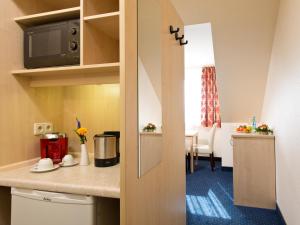 a room with a kitchen with a counter top at ACHAT Hotel Leipzig Messe in Leipzig
